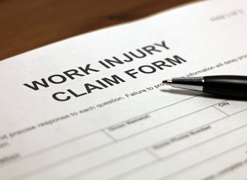 Work injury claim form with a pen on top