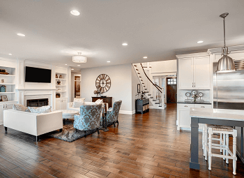 Interior shot of an open concept home living room and kitchen with hardwood floors